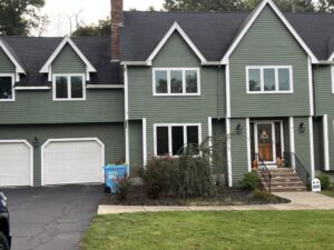 new window installation on a two story green exterior home in Massachusetts