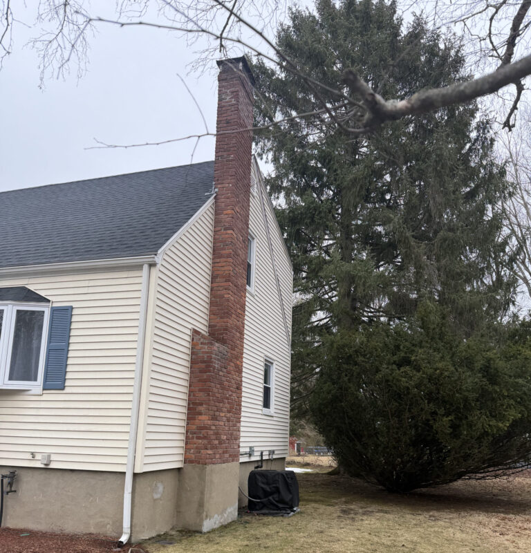 side of a yellow house with tall chimney and newly installed exterior siding