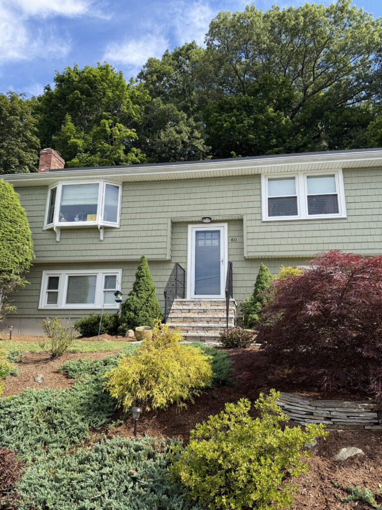 exterior front of green house with vinyl siding
